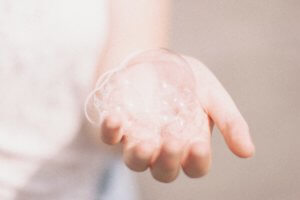 A woman's hand holding soap bubbles 